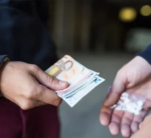 Two people conducting a drug deal in a urban street.