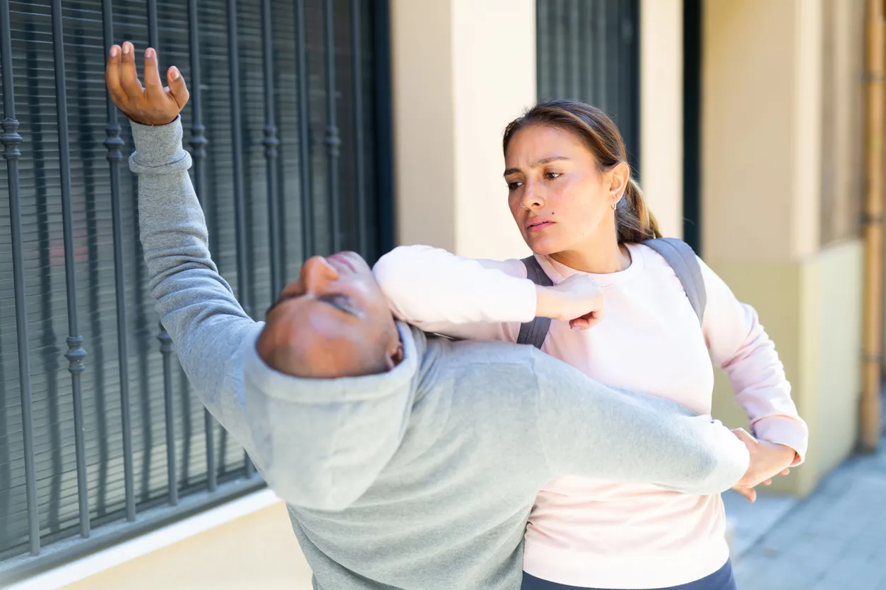 A woman using self defense against a man.