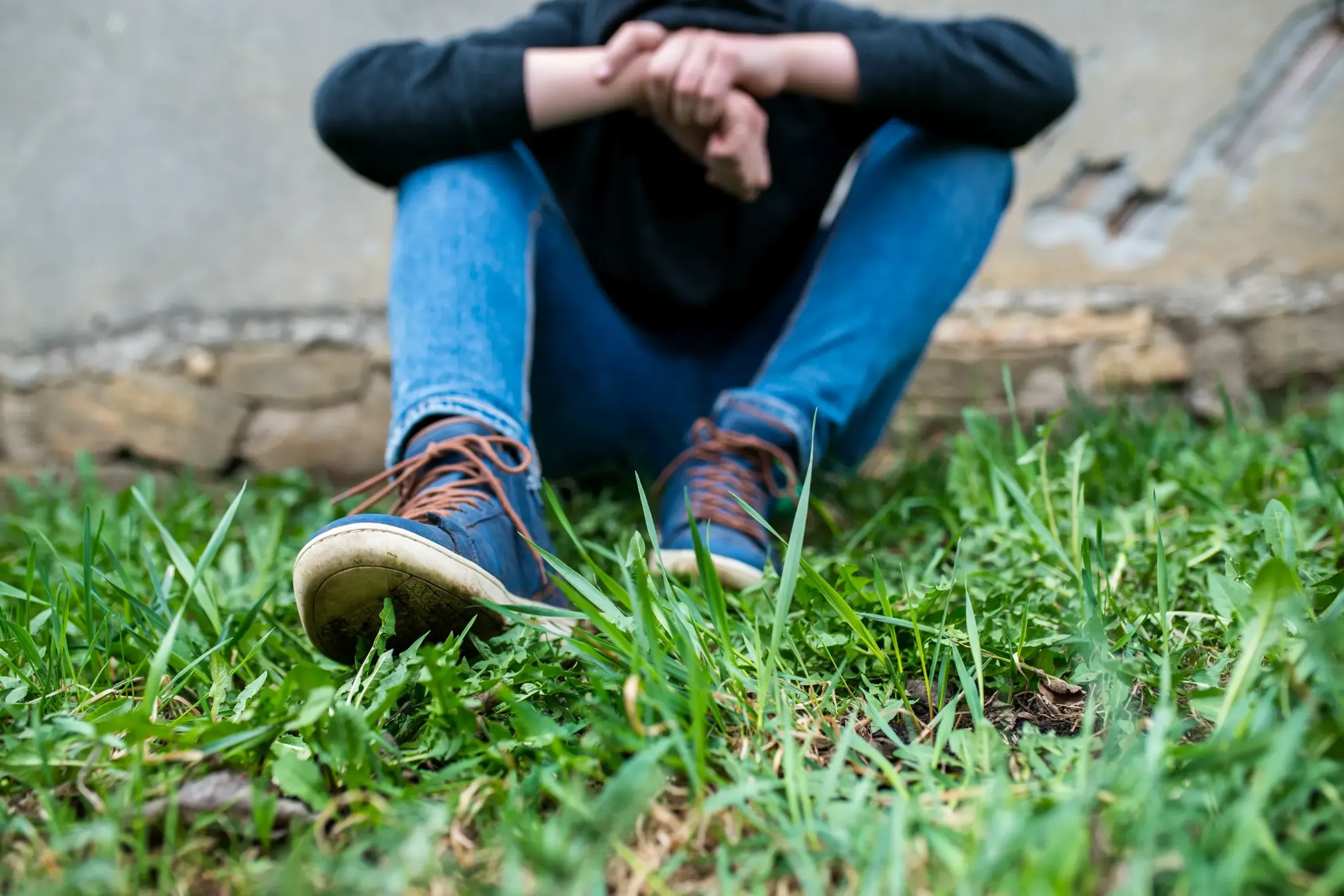 A young person sitting outside.