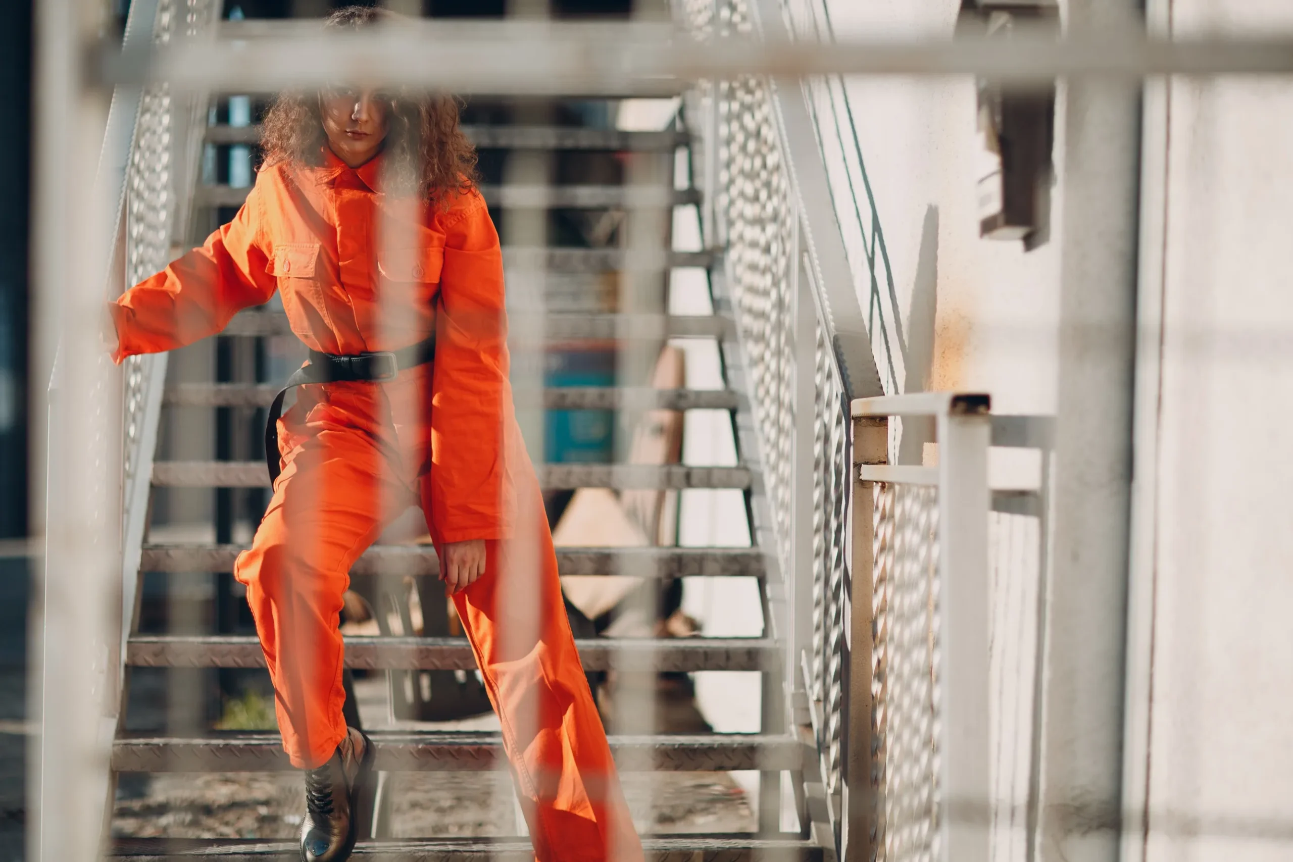 A prisoner behind a tall fence.