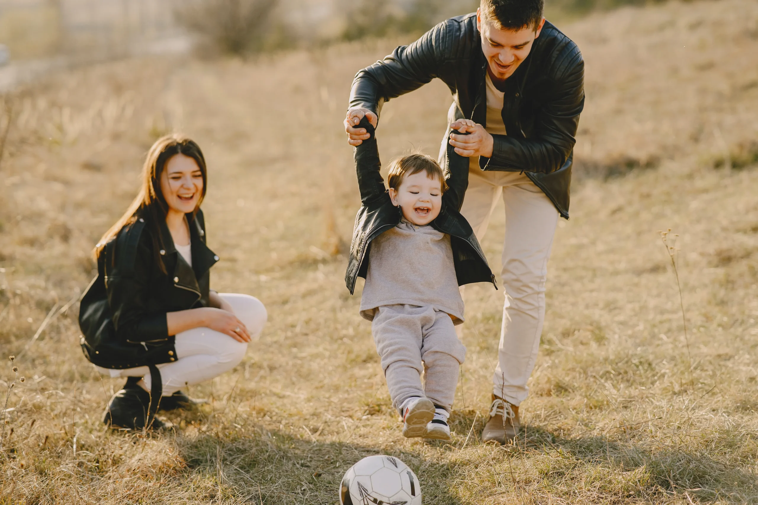 Dad playing with his toddler while the mother looks on.