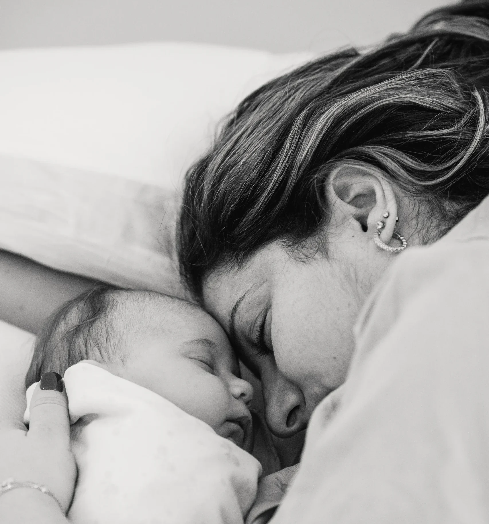 Mother cuddling an infant in black and white. 