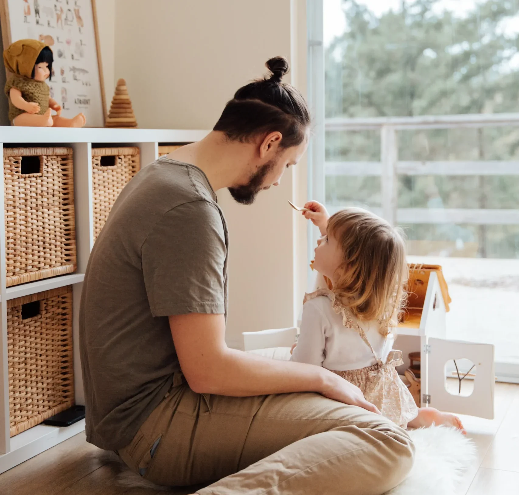  Father and daughter on the floor together playing.
