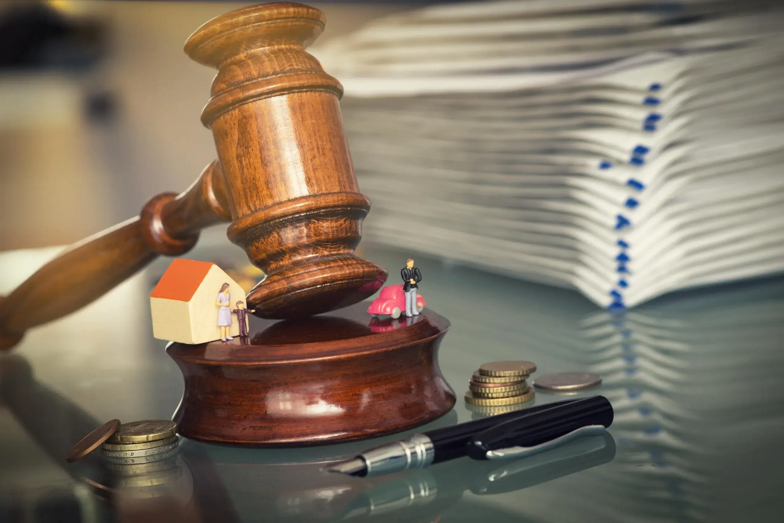 Justice gavel sits between split family assets. For tough disputes on dividing assets in a divorce, call our experienced Sugar Land property division attorney.