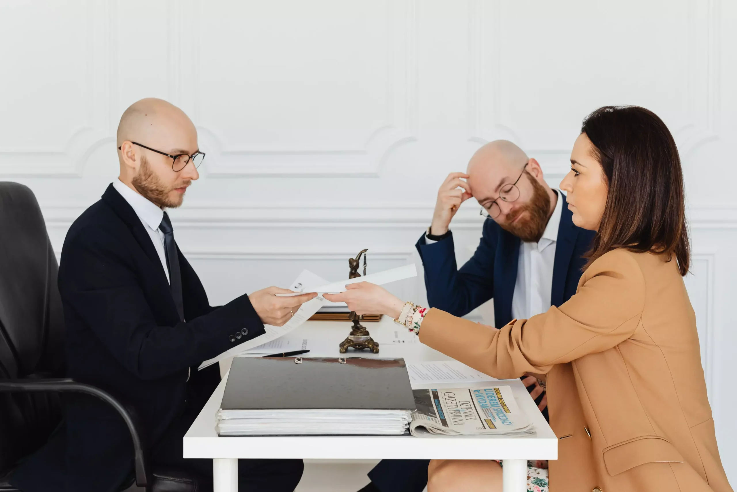 A couple speaking with an attorney at a desk.