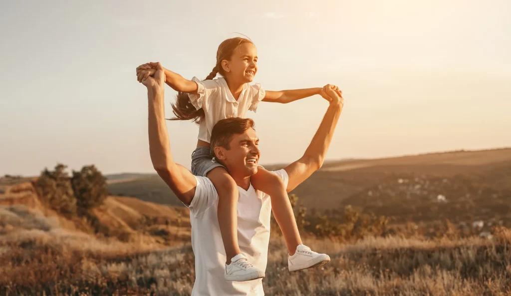 A father with his daughter on his shoulders.
