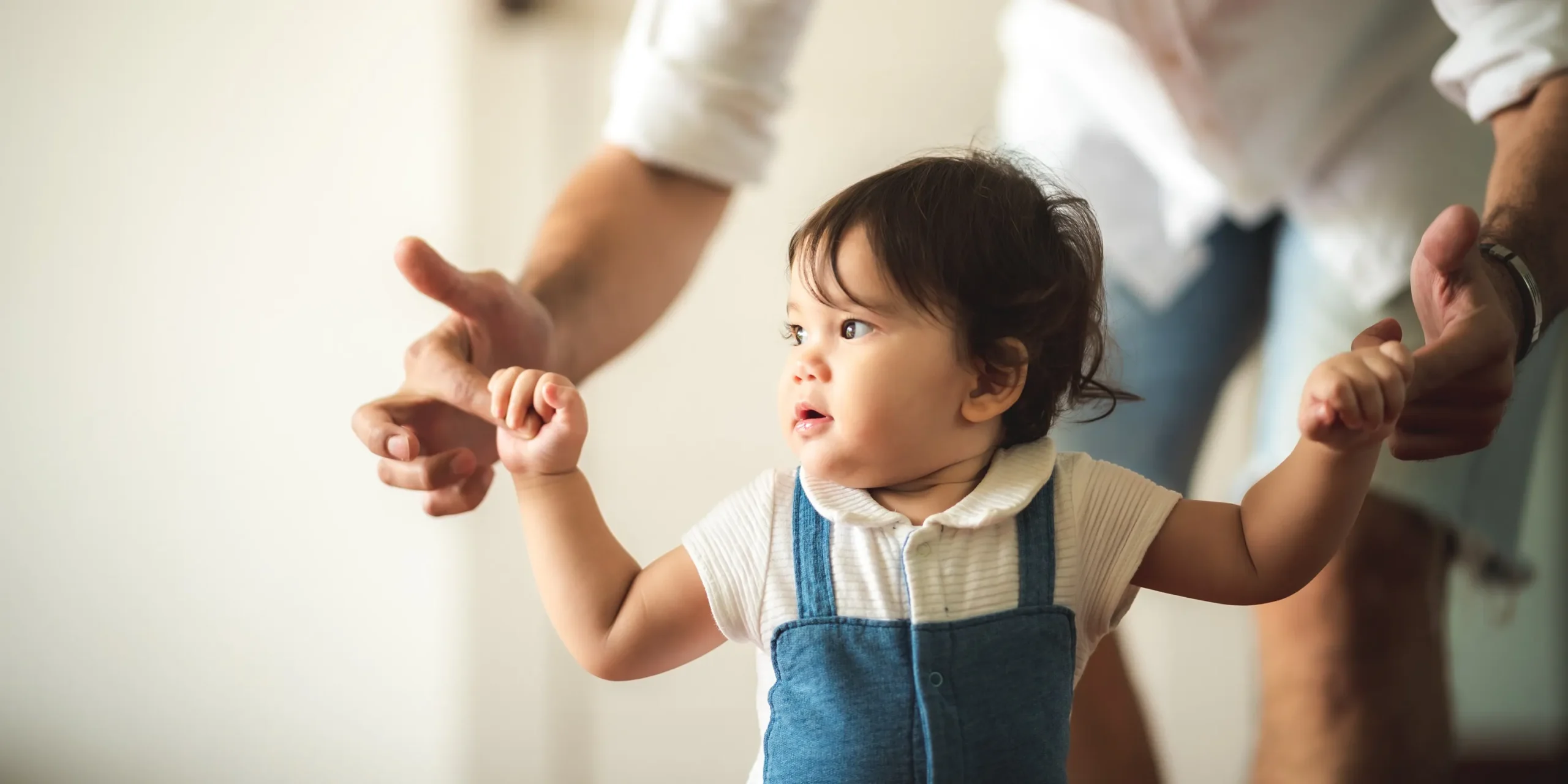 A child holding their parents' hands.