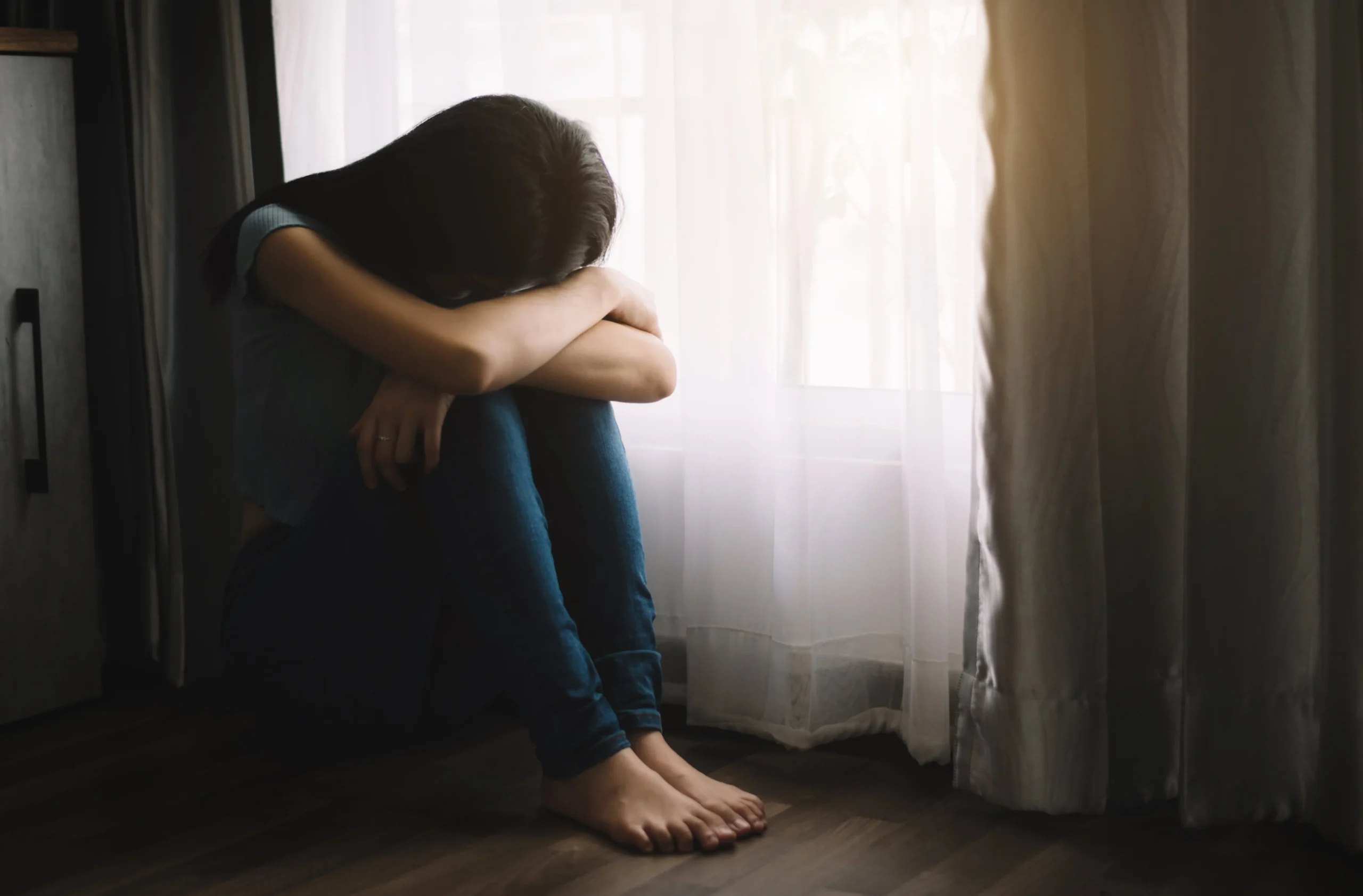 A woman upset with her head down in her arms.