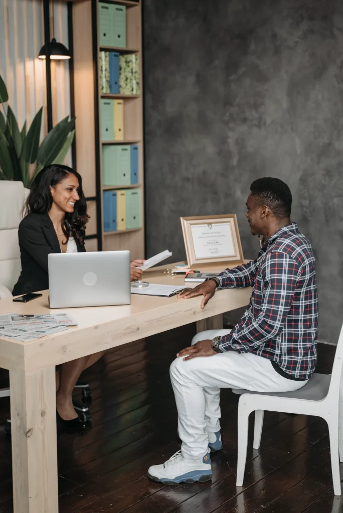 Attorney speaking with her client at a desk.
