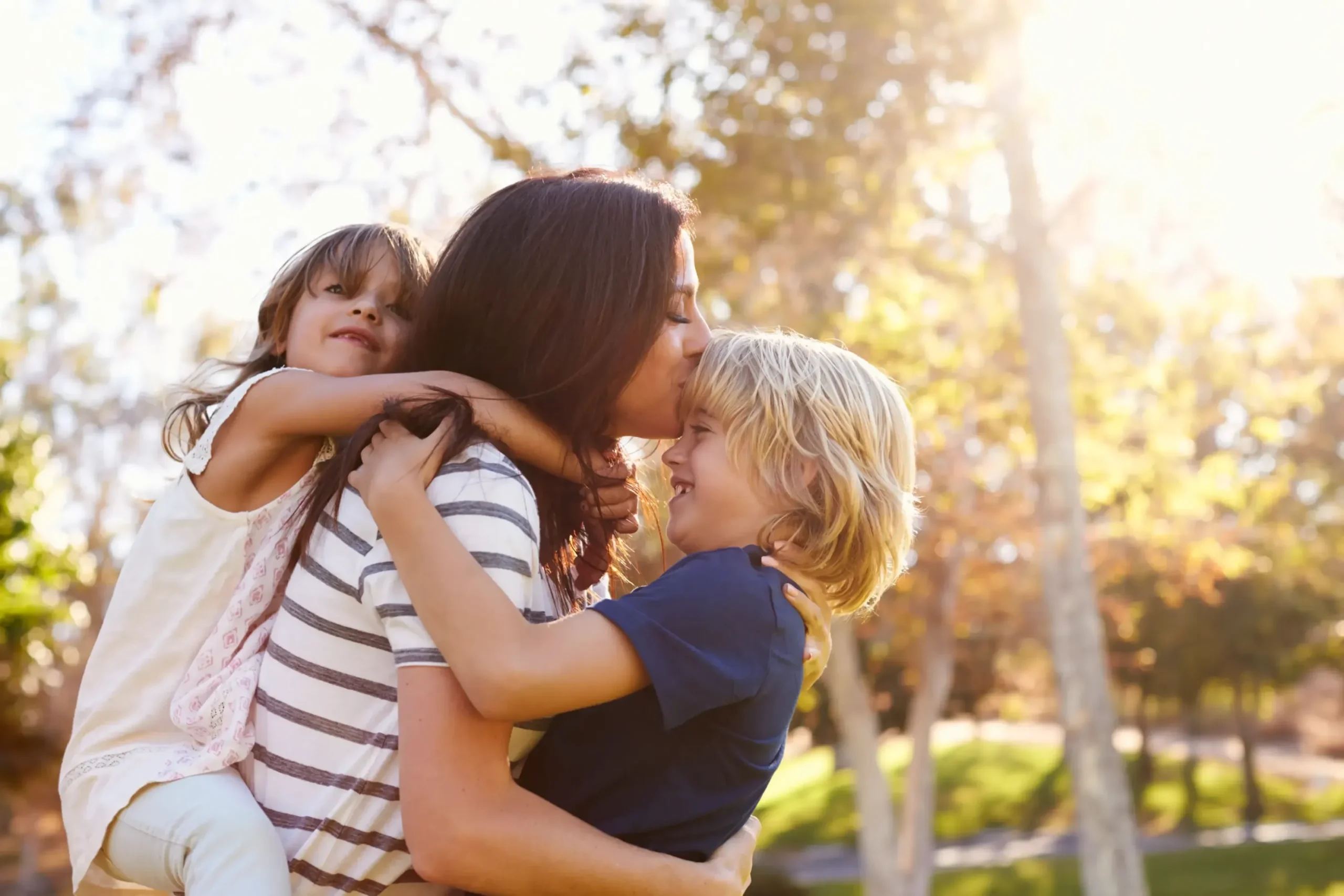 A mom with her two kids outside.