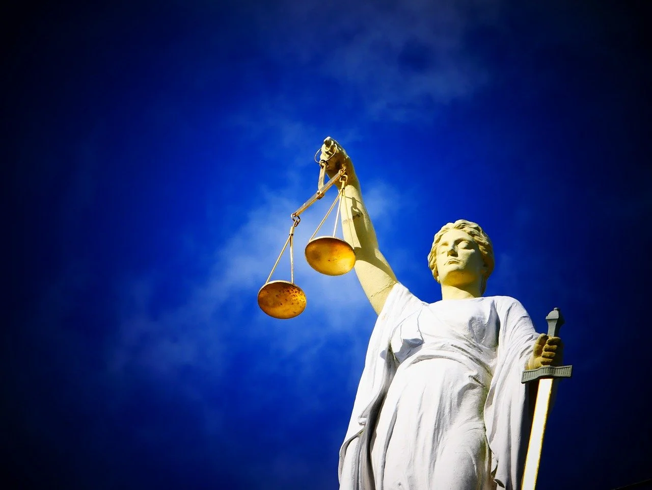 Statute of Justice holding justice scales. 