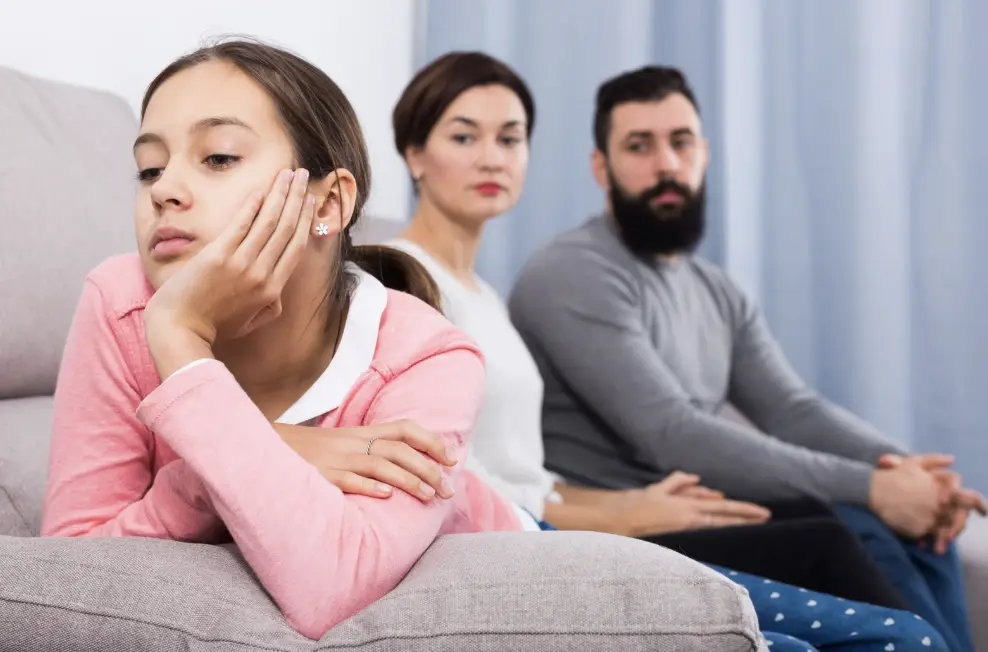 Child appears distant from their parents, highlighting emotional disconnection.